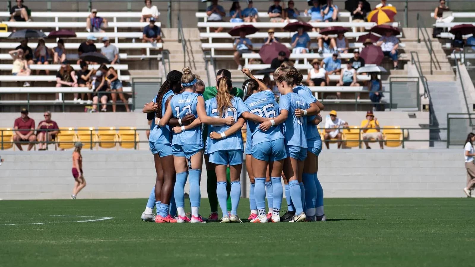 Equipo femenino de fútbol en círculo antes del partido
