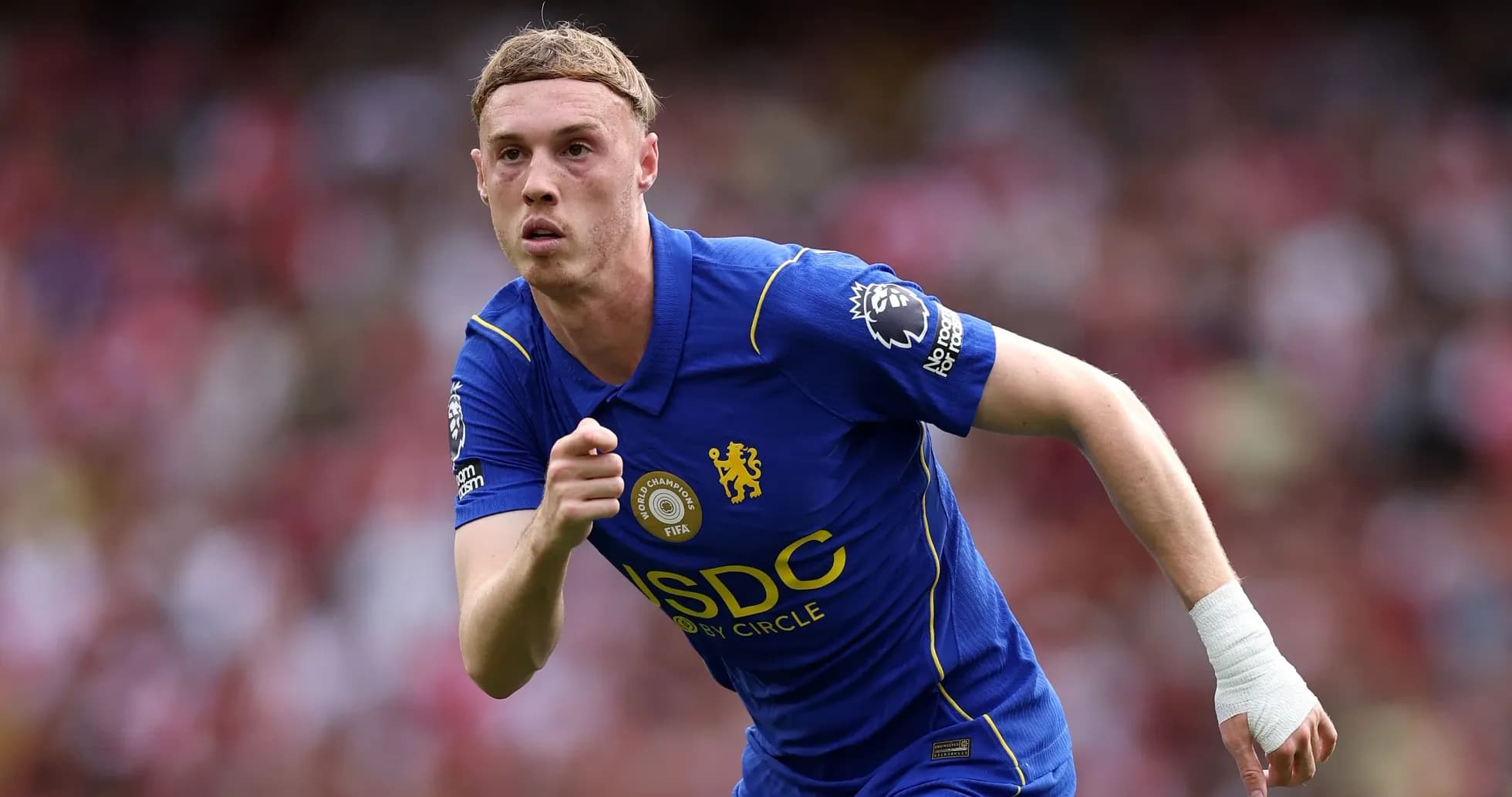 Jugador corriendo con camiseta de Chelsea durante partido