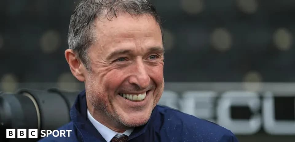 Hombre sonriendo en un entorno deportivo lluvioso