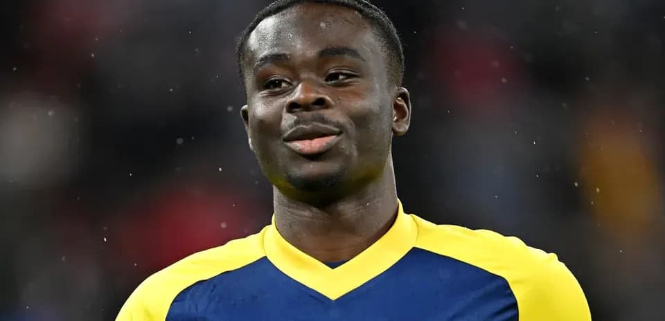 Jugador con camiseta del Arsenal sonriendo en el campo