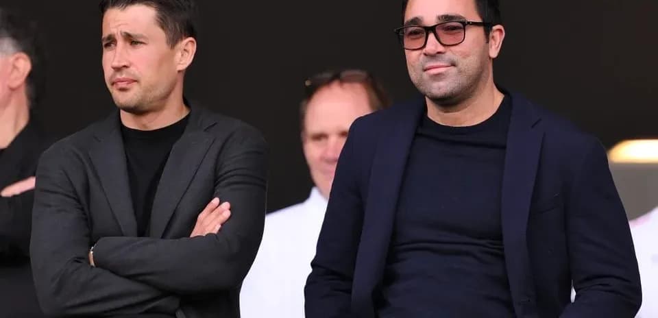 Dos hombres observando un evento deportivo desde gradas