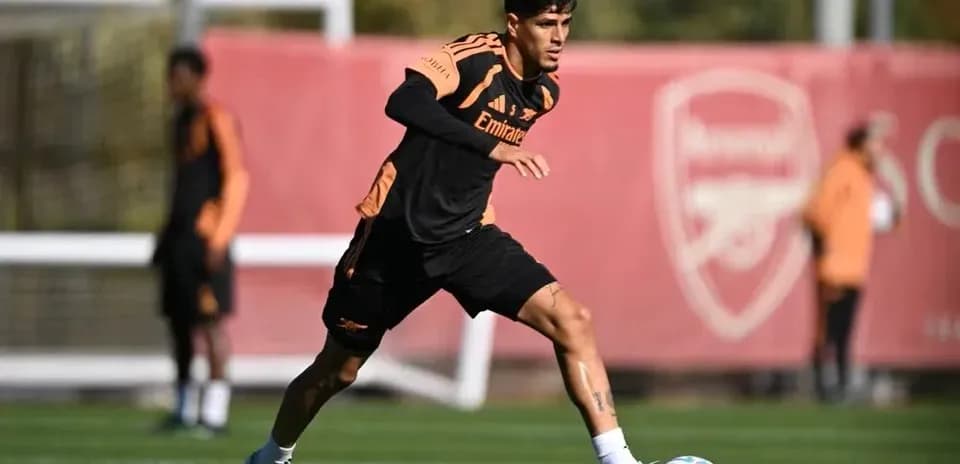 Jugador entrenando con balón en campo de fútbol