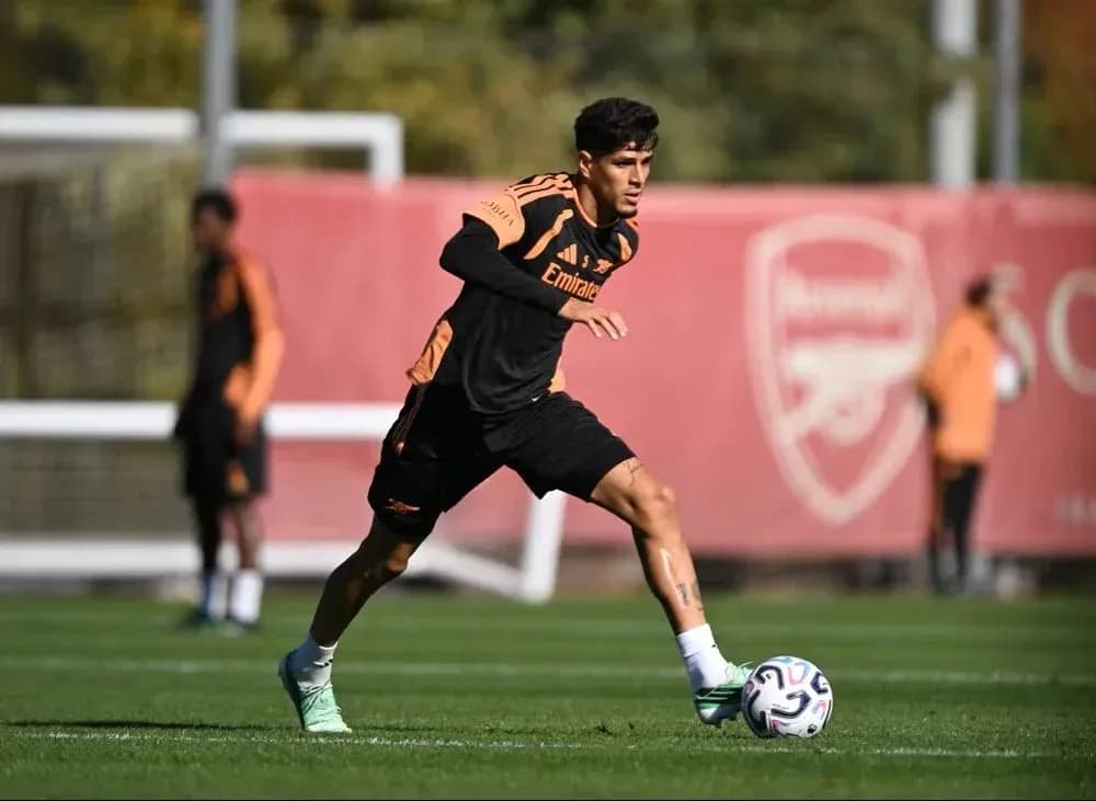 Jugador entrenando con balón en campo de fútbol