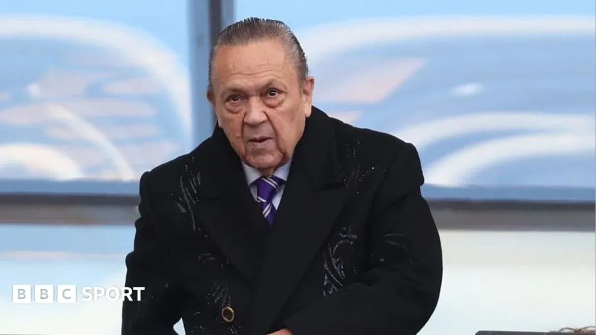 Hombre con abrigo oscuro en un evento deportivo