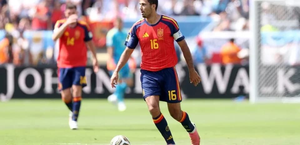 Jugador español corriendo con el balón durante partido