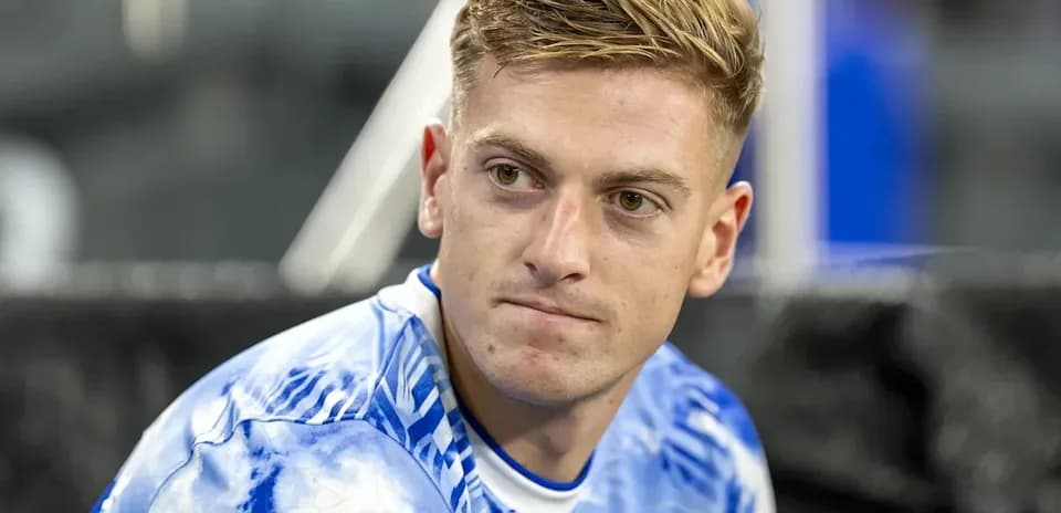 Jugador sentado con camiseta azul y blanca