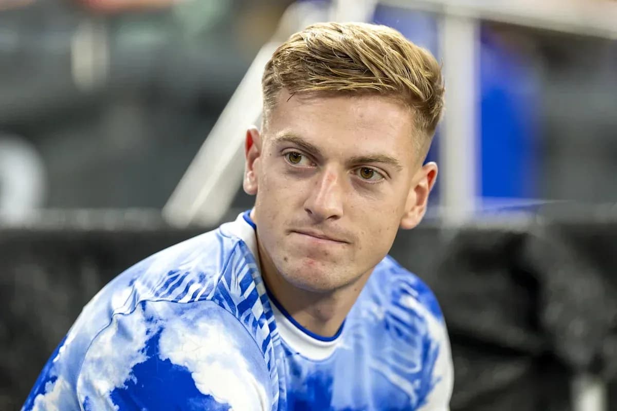 Jugador sentado con camiseta azul y blanca