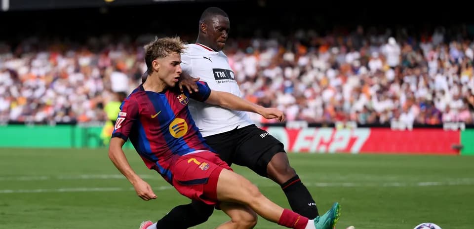Jugador de Barcelona siendo tackleado por oponente