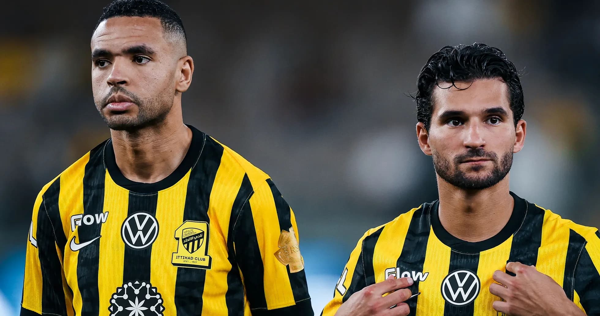 Dos jugadores de Ittihad en uniforme amarillo y negro