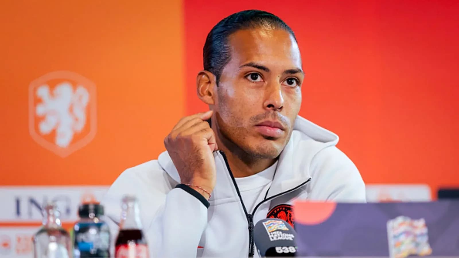 Jugador en conferencia de prensa con fondo naranja