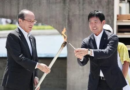 Dos hombres encendiendo una antorcha ceremonial