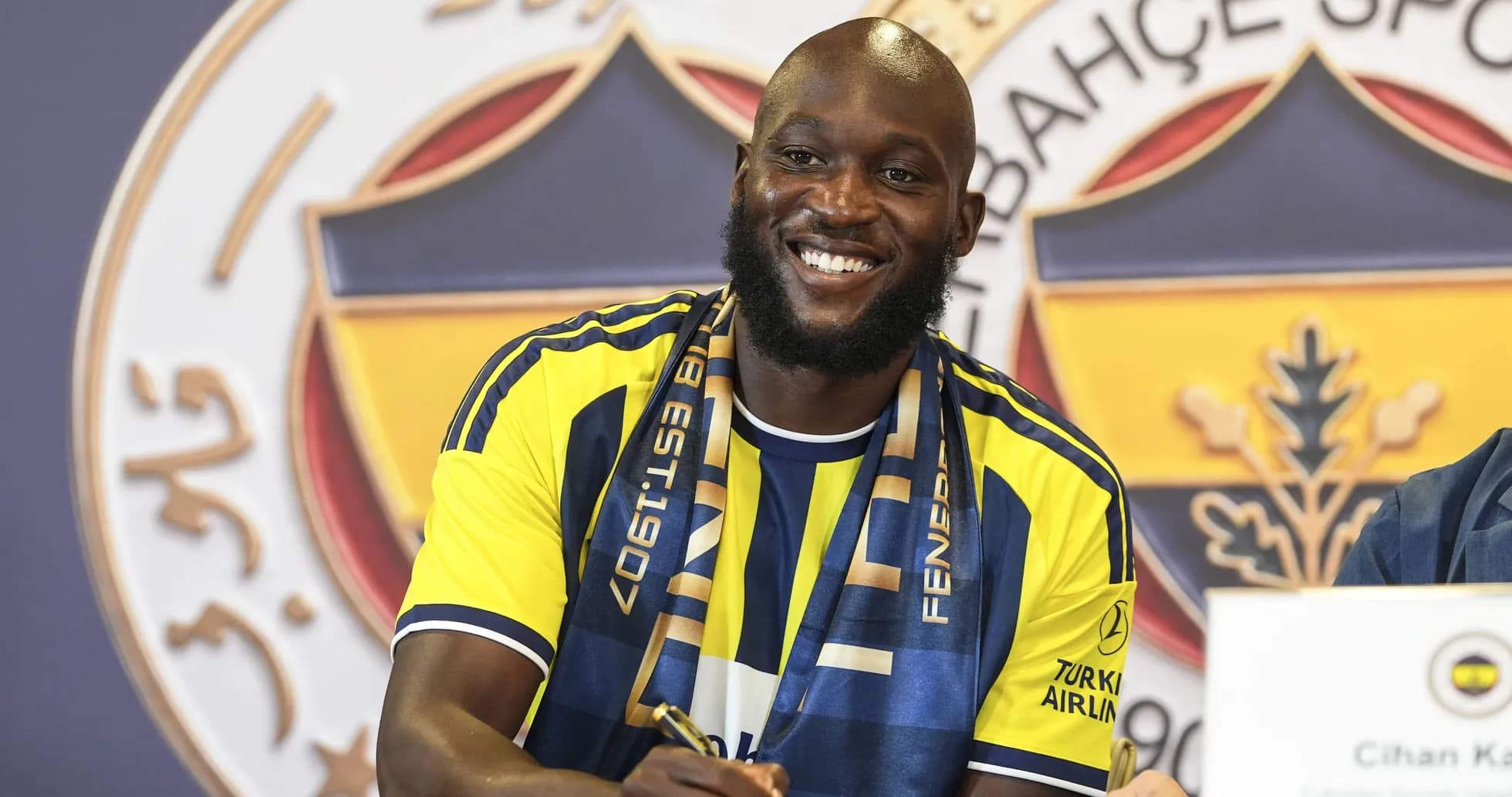 Jugador sonriendo durante la firma de contrato