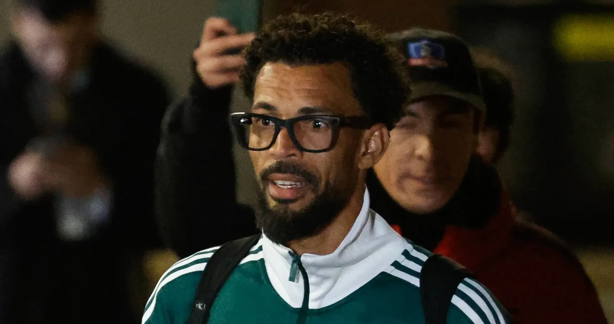 Jugador saliendo con chaqueta deportiva y gafas