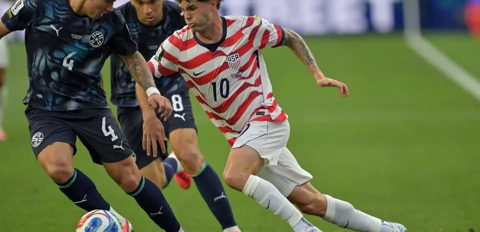Christian Pulisic dribbling past opposing player