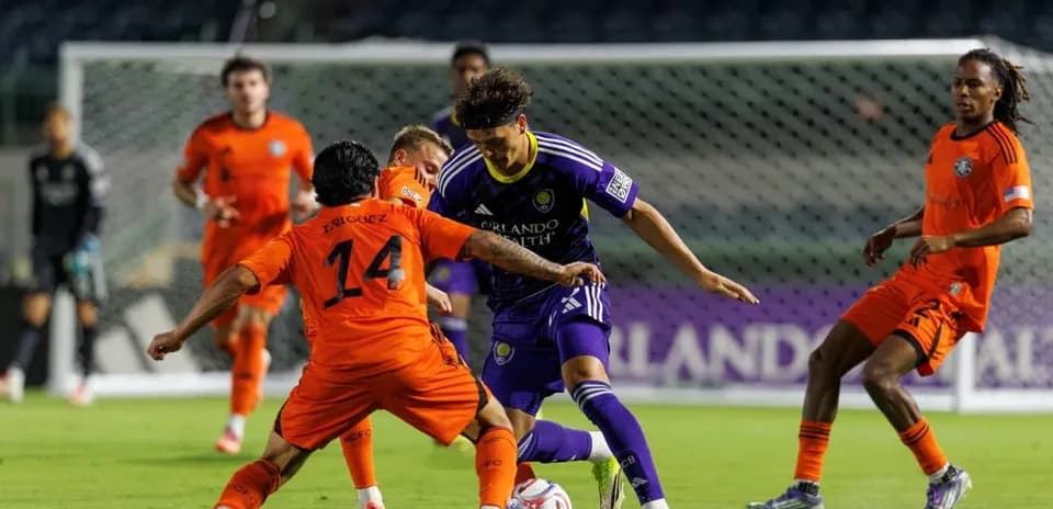 Enriquez y jugador de Orlando City II en acción