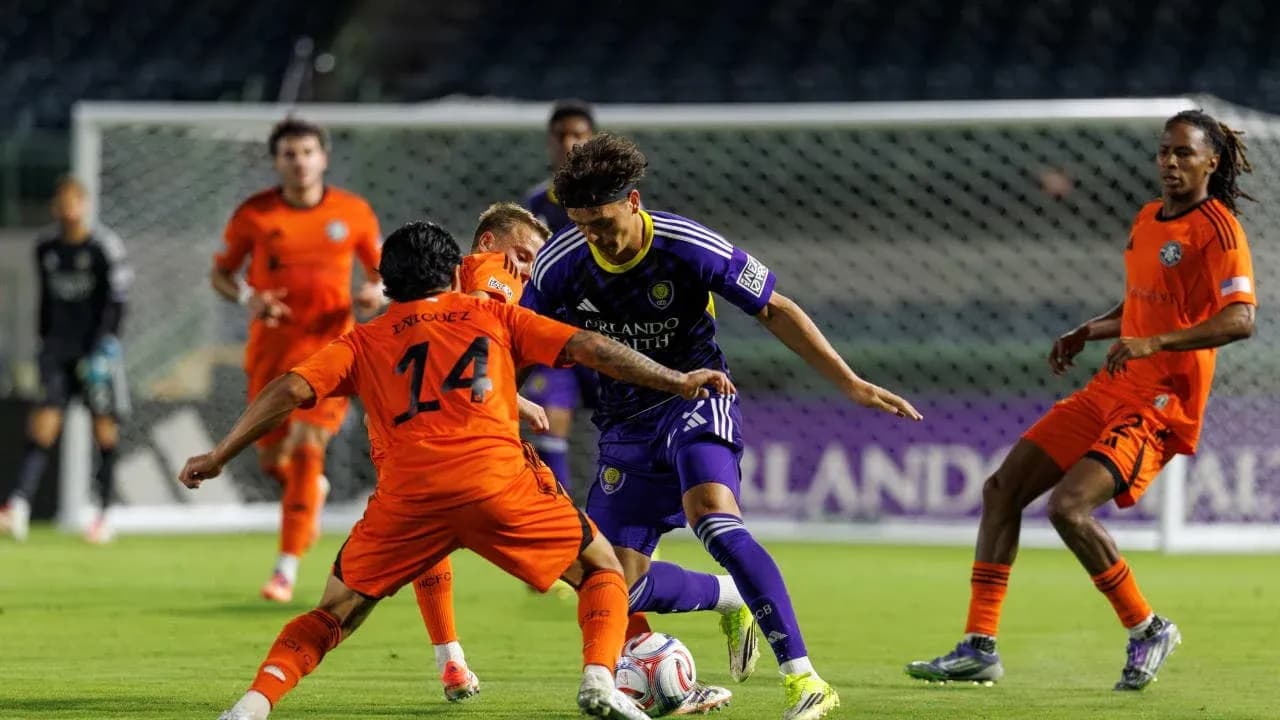 Enriquez y jugador de Orlando City II en acción
