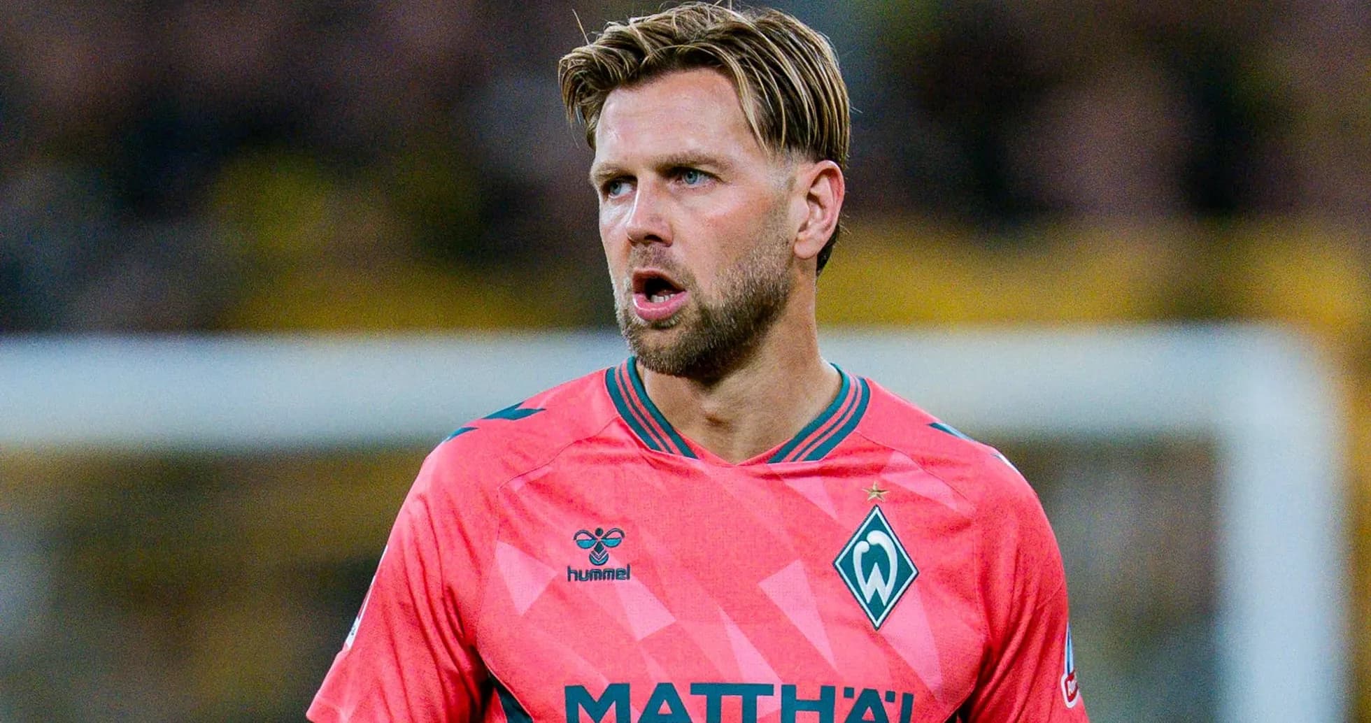 Jugador de Werder Bremen en uniforme rosa durante partido