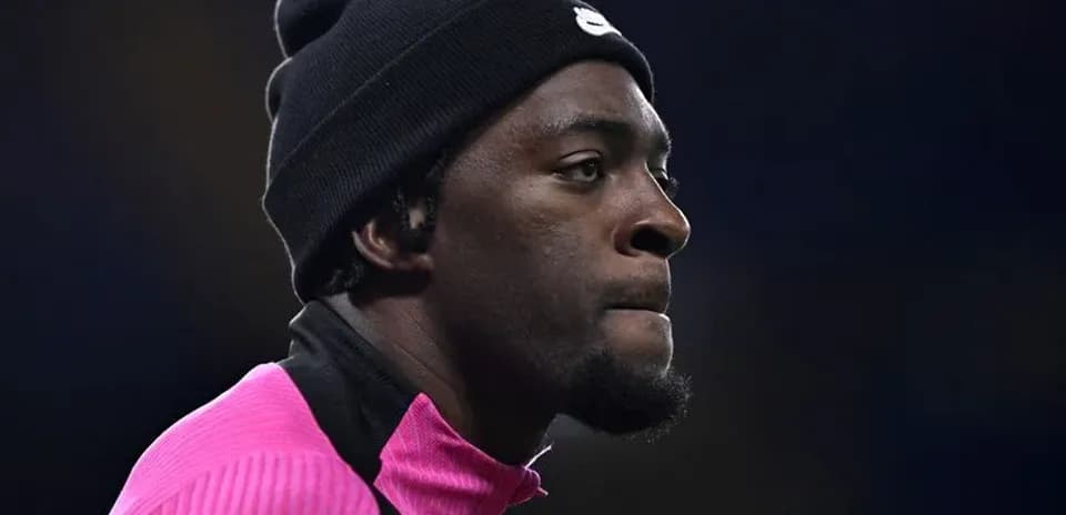 Jugador con gorro y sudadera rosa en el campo
