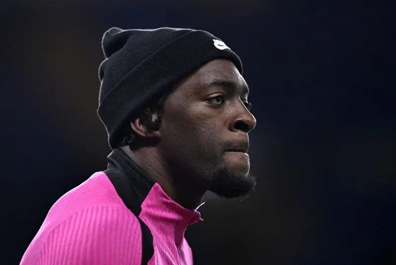 Jugador con gorro y sudadera rosa en el campo