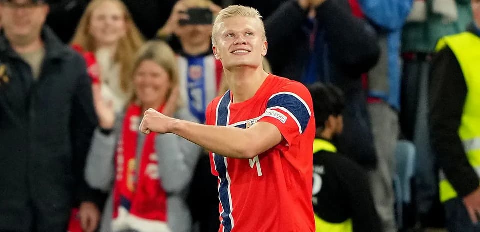 Jugador celebrando un gol con aficionados al fondo