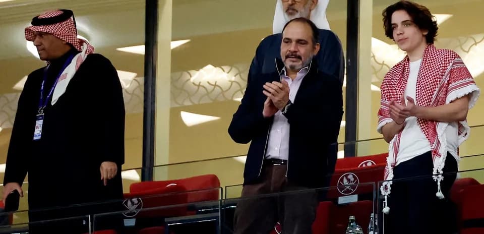 Cuatro personas aplaudiendo en el palco del estadio