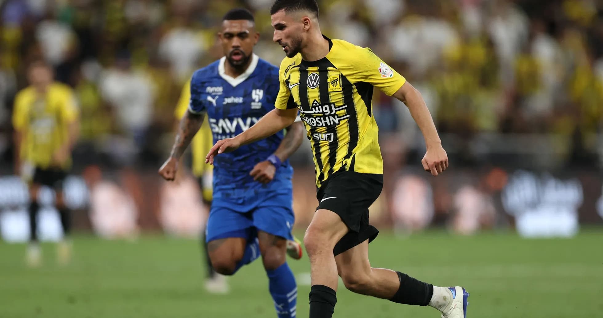 Jugador de Al Ittihad driblando a oponente de Al Hilal