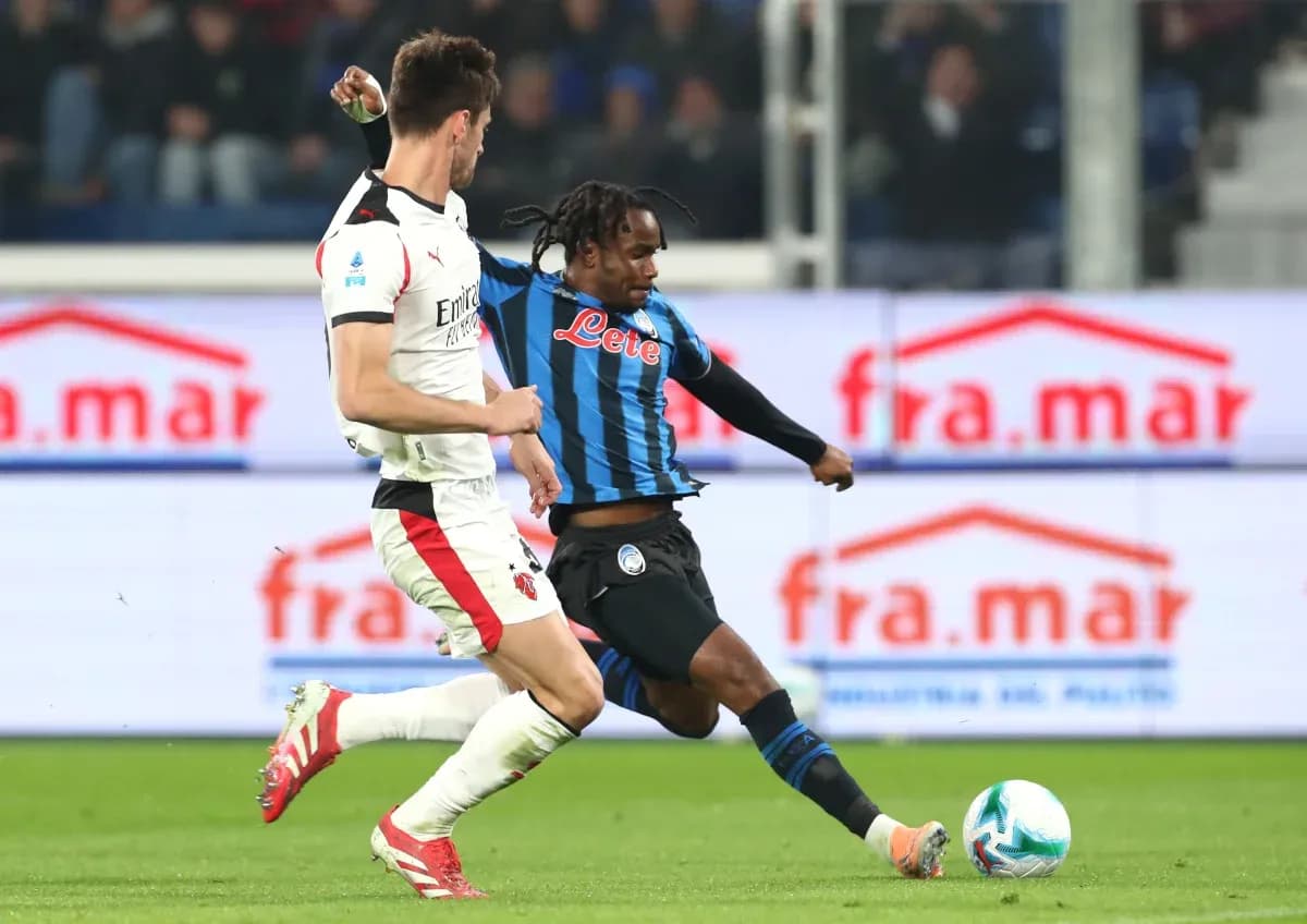 Jugador de Atalanta intenta driblar a defensor de AC Milan