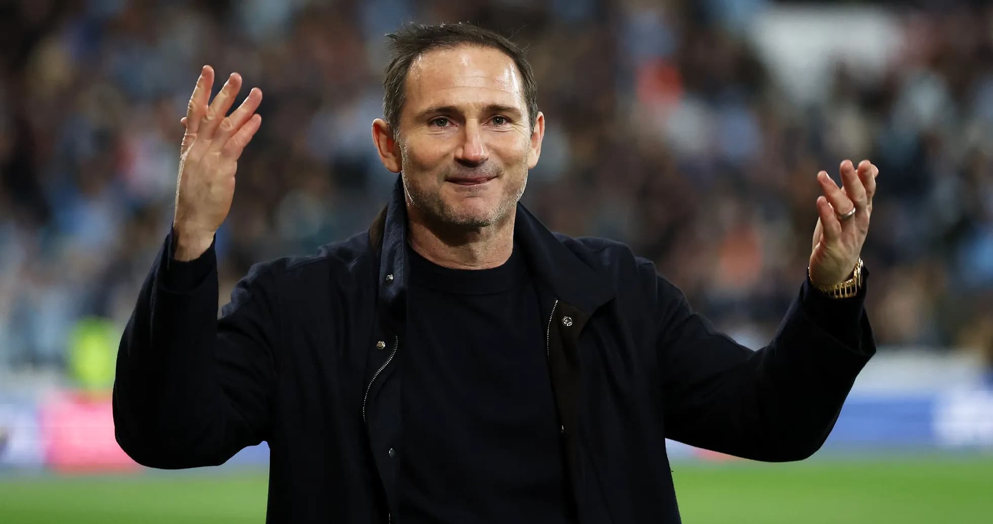 Entrenador saludando a los aficionados en el estadio
