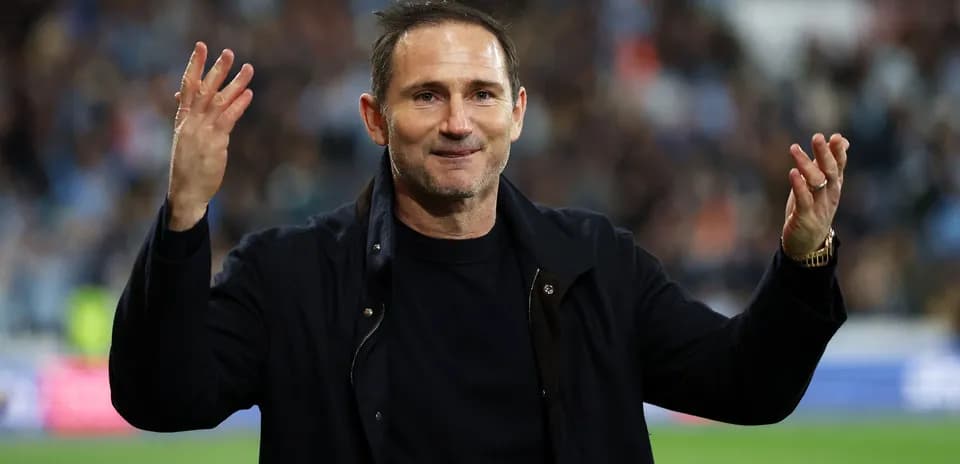 Entrenador saludando a los aficionados en el estadio