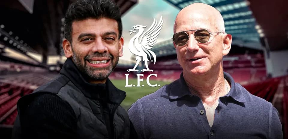 Dos hombres sonriendo en Anfield con logo de L.F.C.