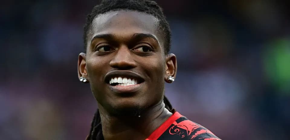 Jugador sonriendo con camiseta roja en el campo