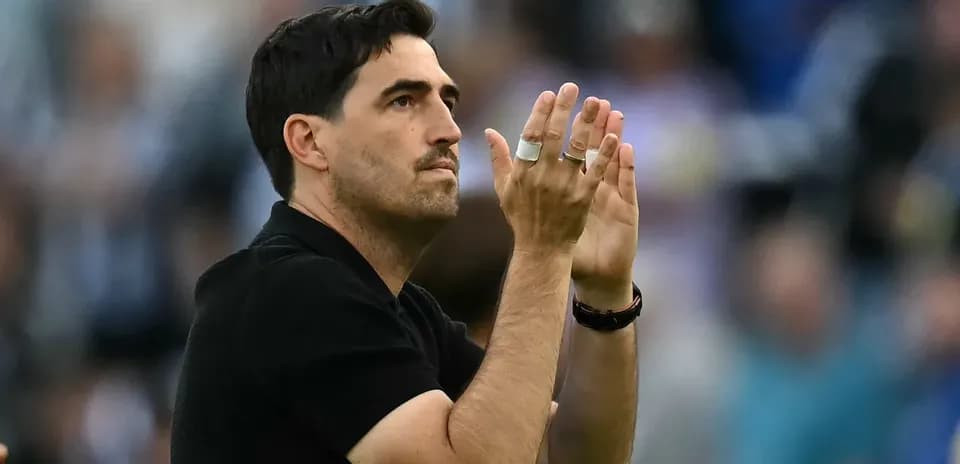 Entrenador aplaudiendo desde la línea de banda