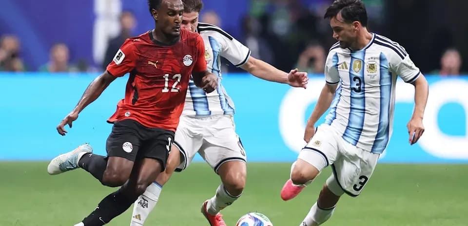 Jugador de Egipto driblando entre defensores argentinos