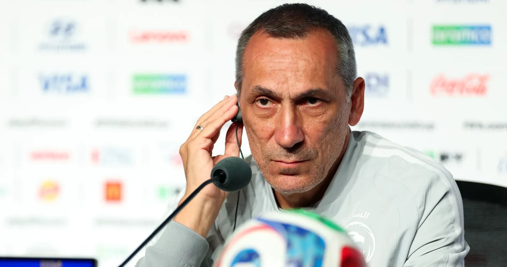 Entrenador en conferencia de prensa con micrófono