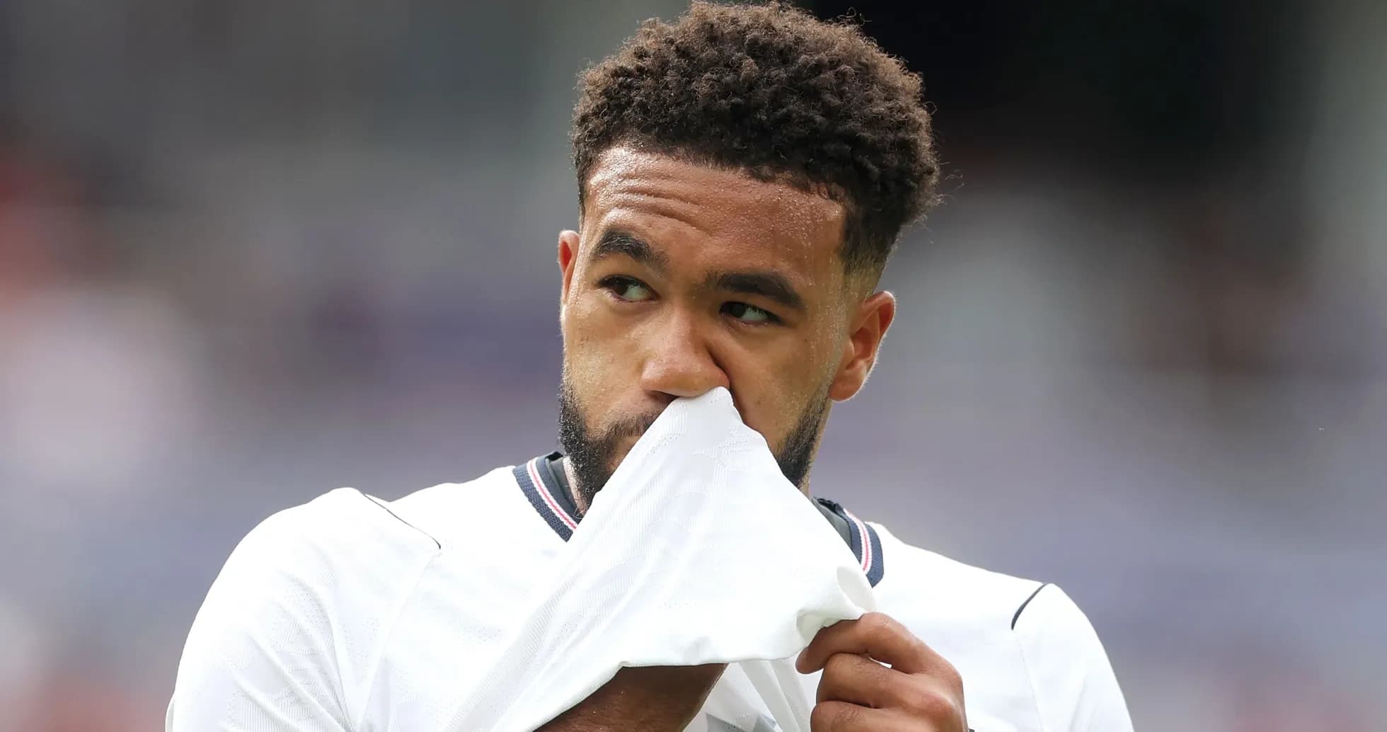 Jugador sosteniendo su camiseta en el campo