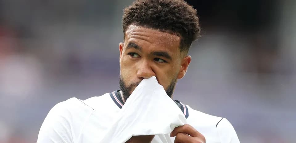 Jugador sosteniendo su camiseta en el campo