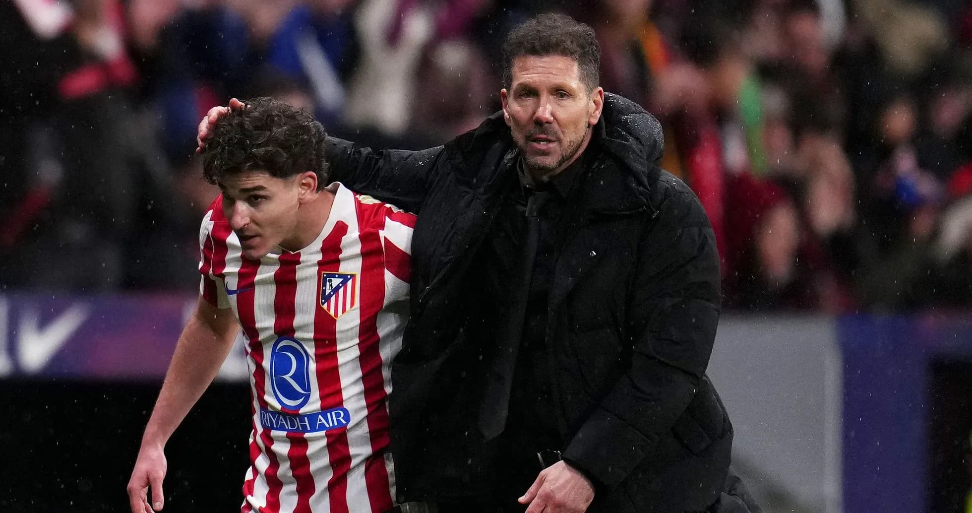 Entrenador ayudando a jugador de Atlético de Madrid