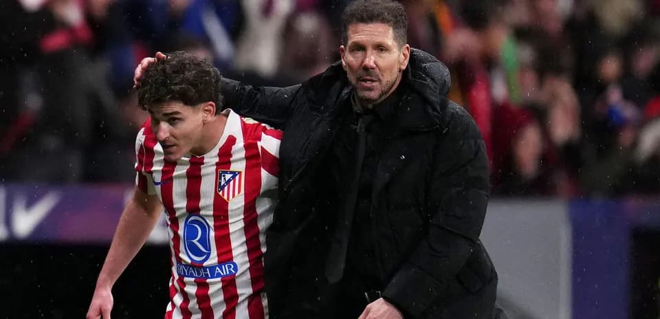 Entrenador ayudando a jugador de Atlético de Madrid