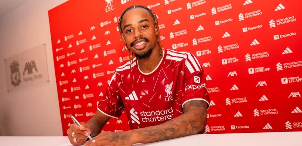 Jugador firmando contrato con Liverpool en conferencia