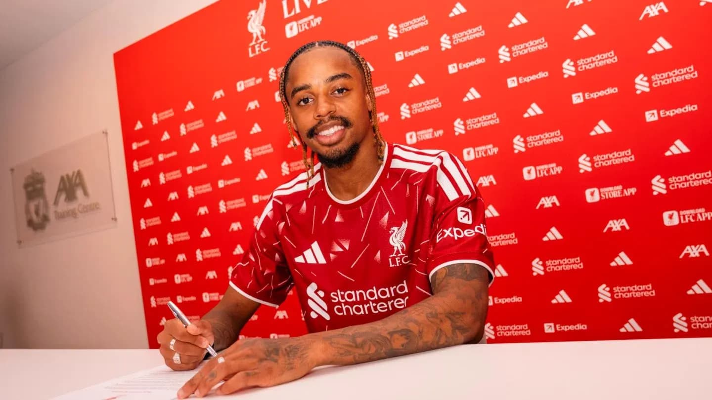 Jugador firmando contrato con Liverpool en conferencia