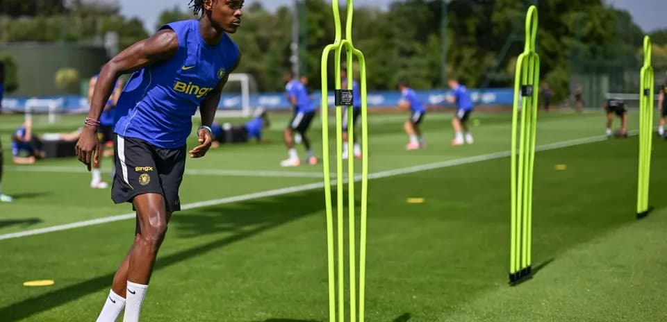 Jugador entrenando en campo con conos de práctica