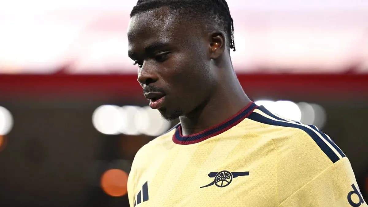 Jugador de Arsenal en camiseta amarilla, mirando hacia abajo