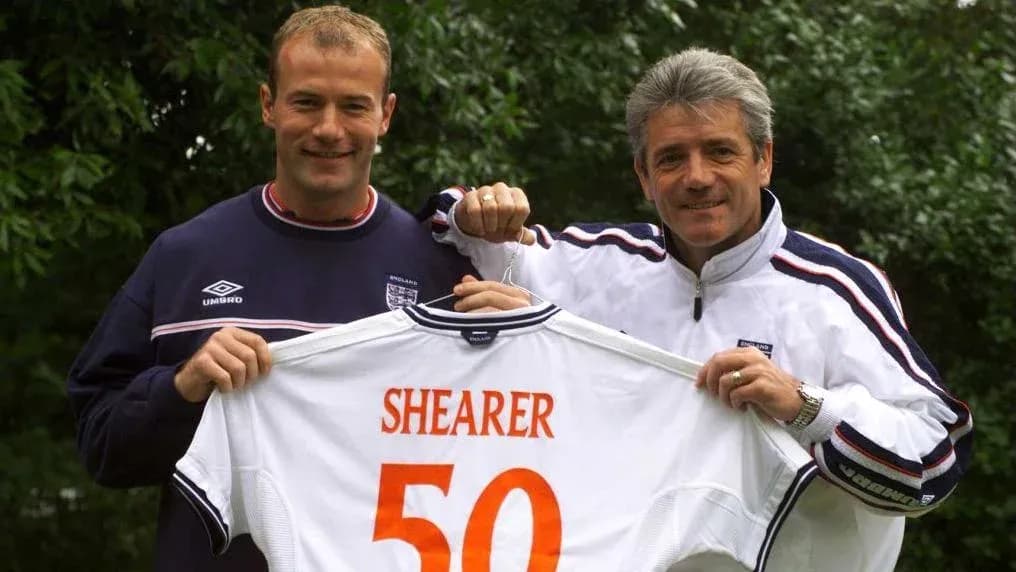 Alan Shearer y entrenador sosteniendo camiseta con número 50