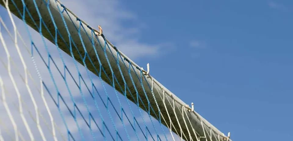 Red de un arco de fútbol contra cielo azul