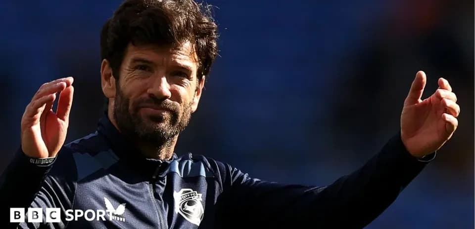 Entrenador saludando durante un partido de fútbol