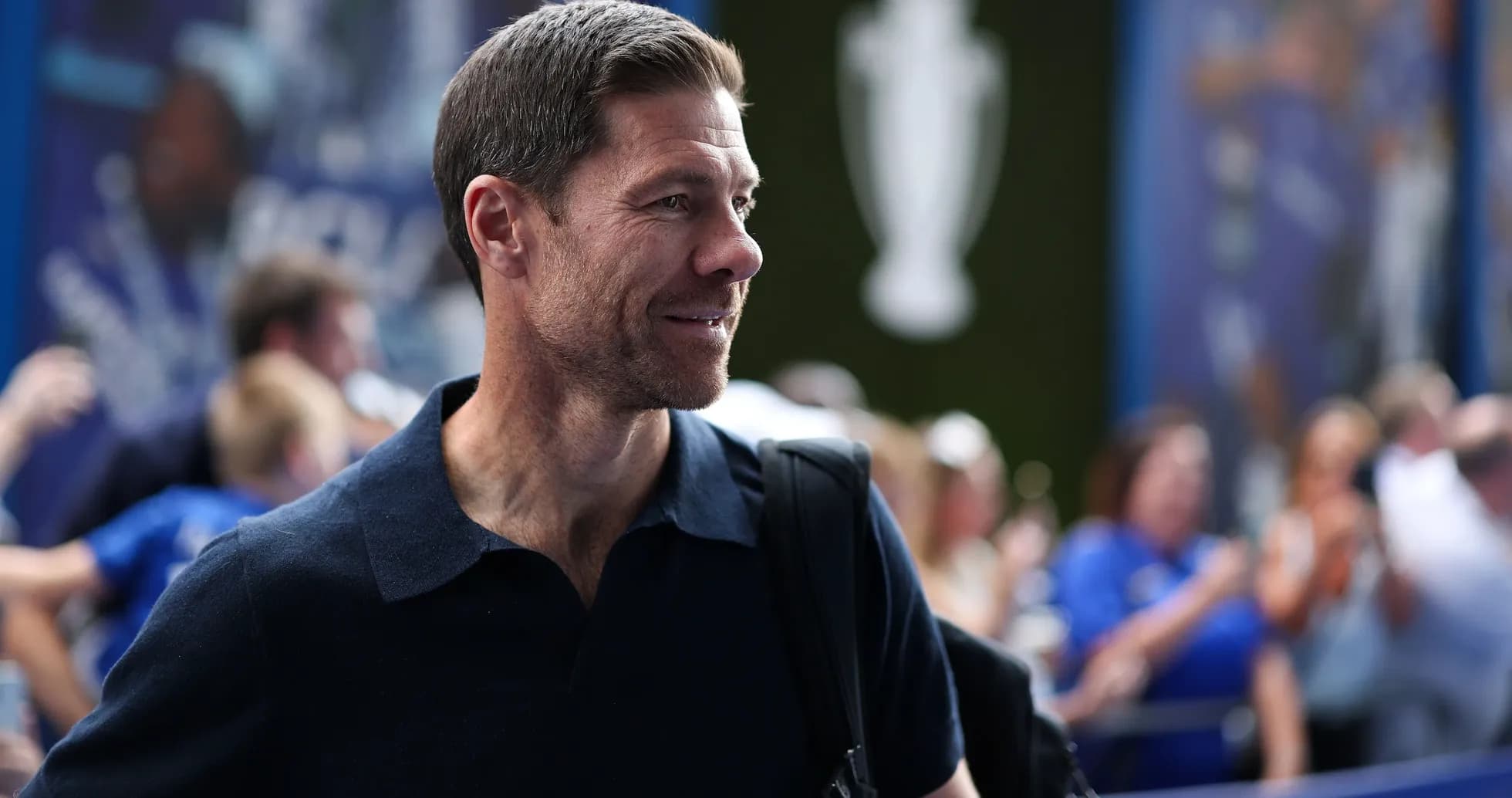 Hombre sonriendo con mochila en evento deportivo