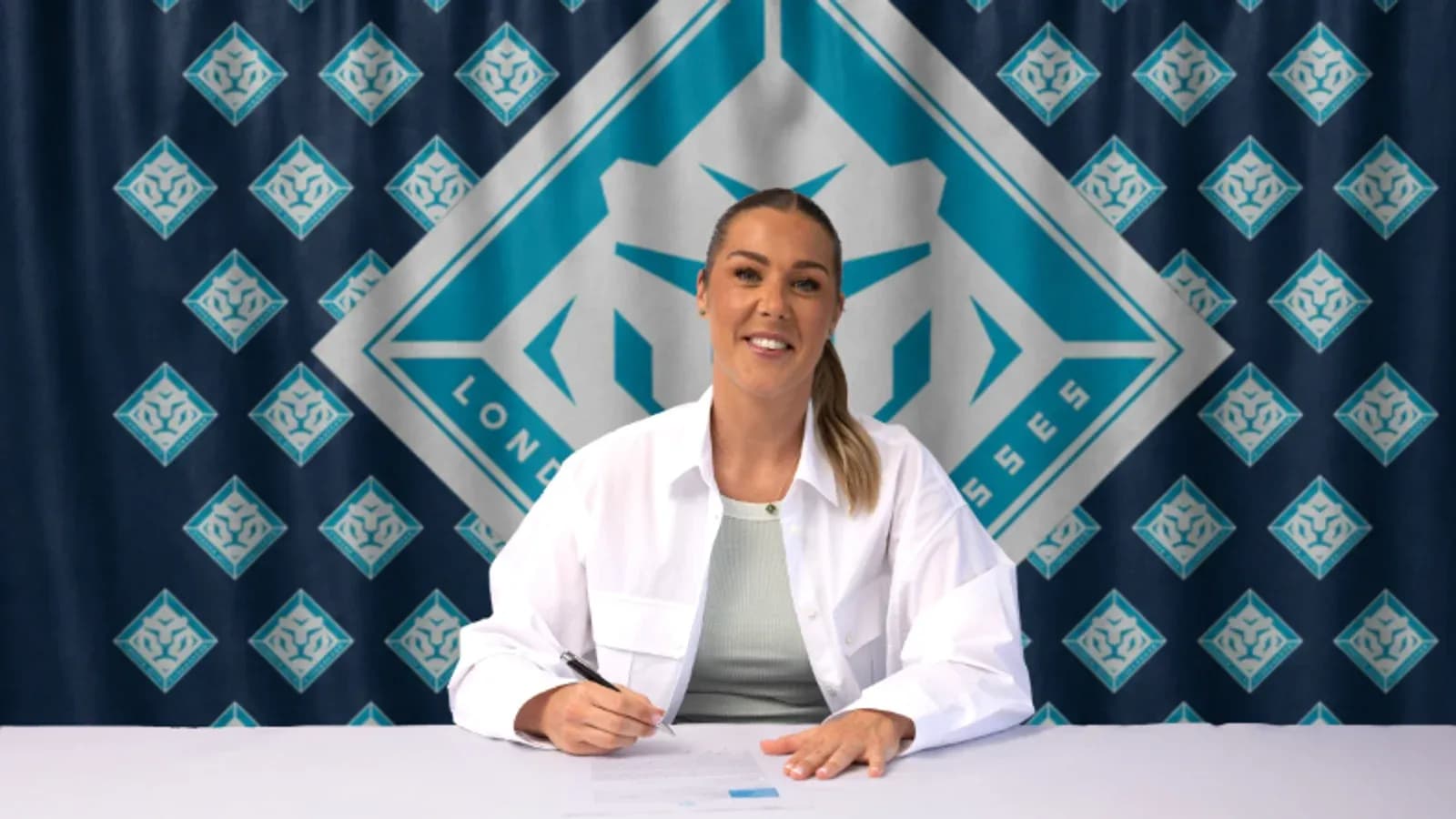 Jugadora firmando contrato en mesa con fondo de equipo