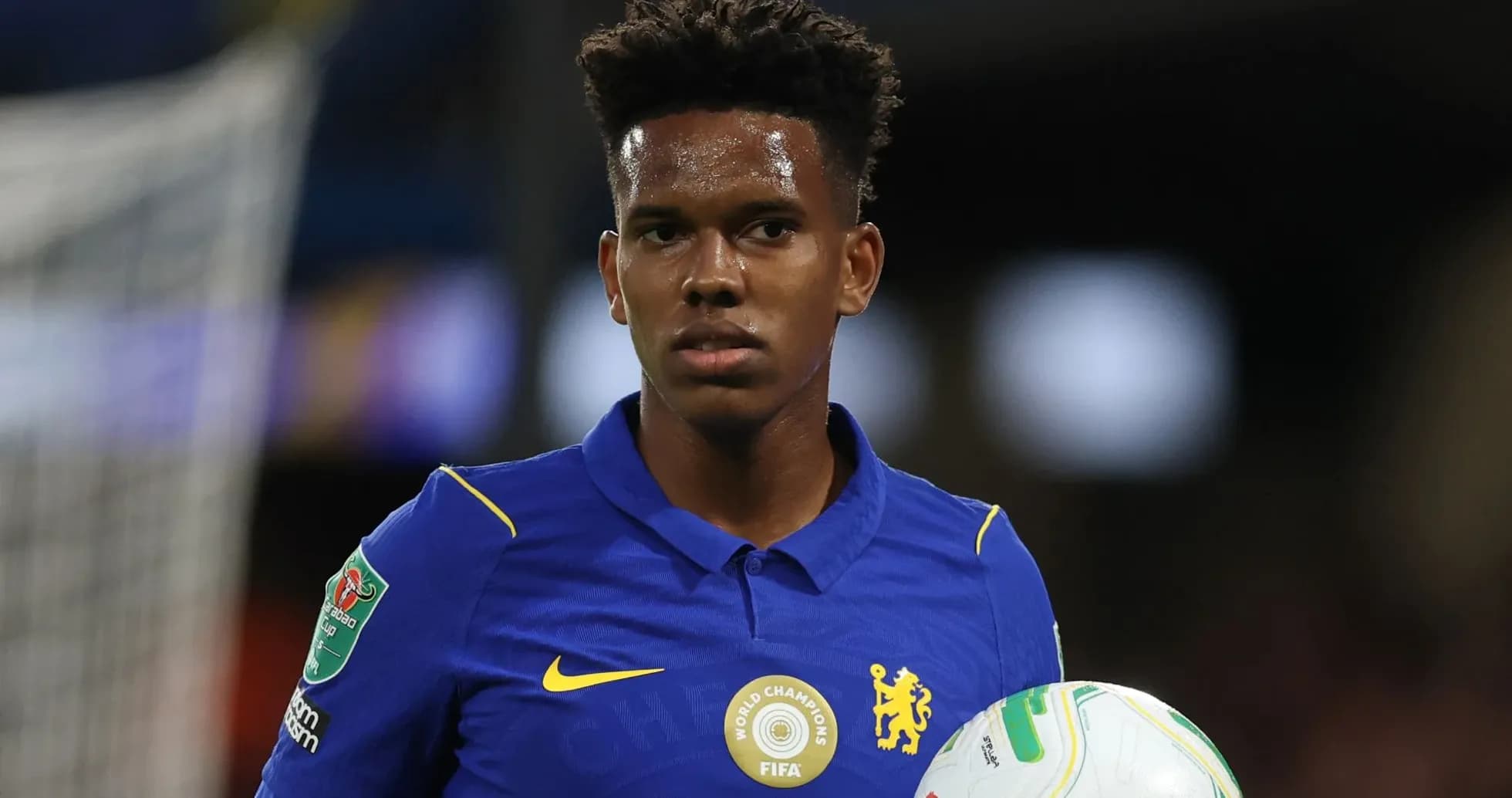 Jugador de Chelsea sosteniendo un balón en el campo