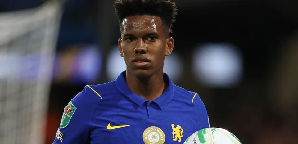Jugador de Chelsea sosteniendo un balón en el campo