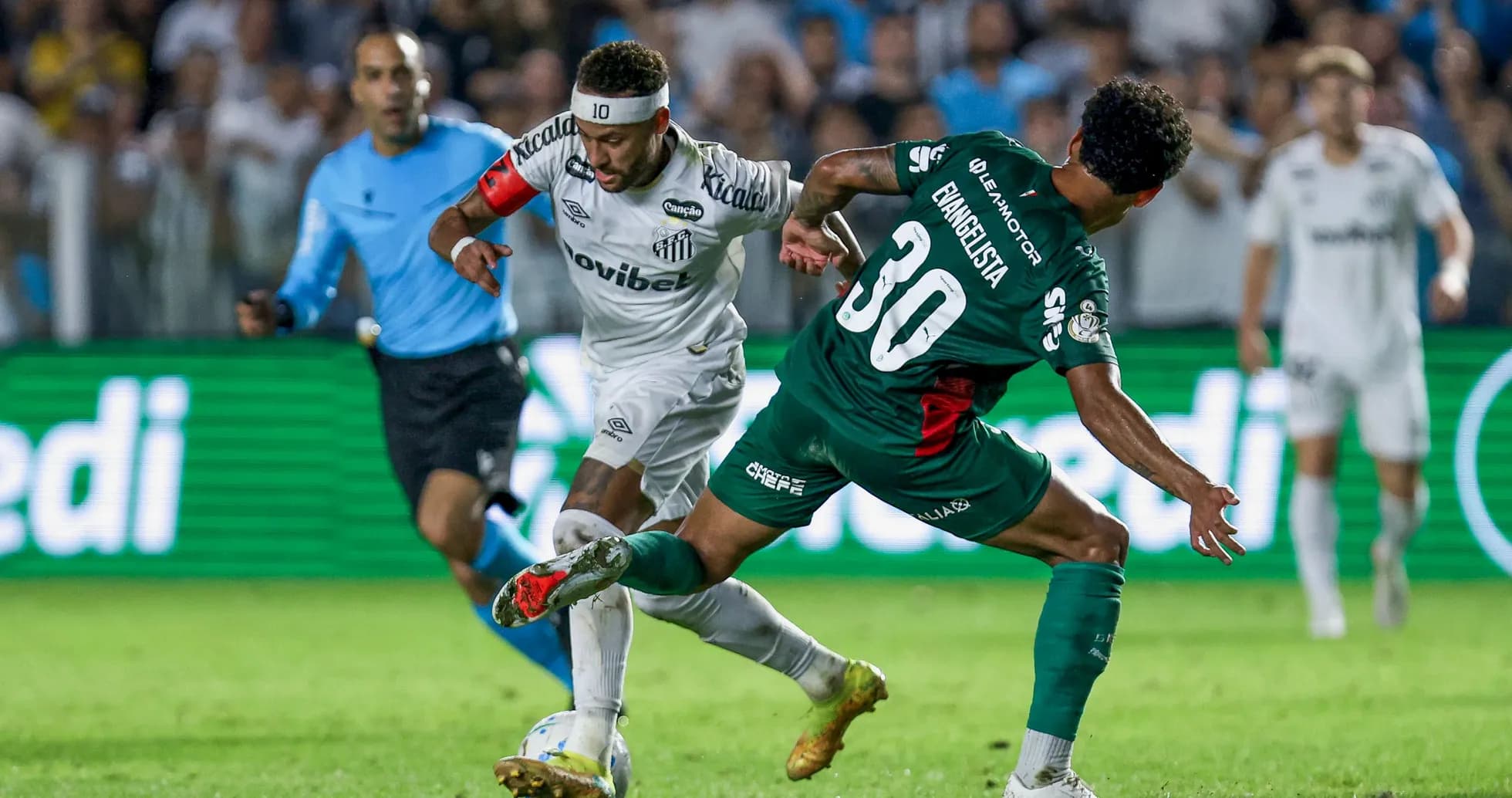 Jugador de Santos driblando a defensor rival en partido